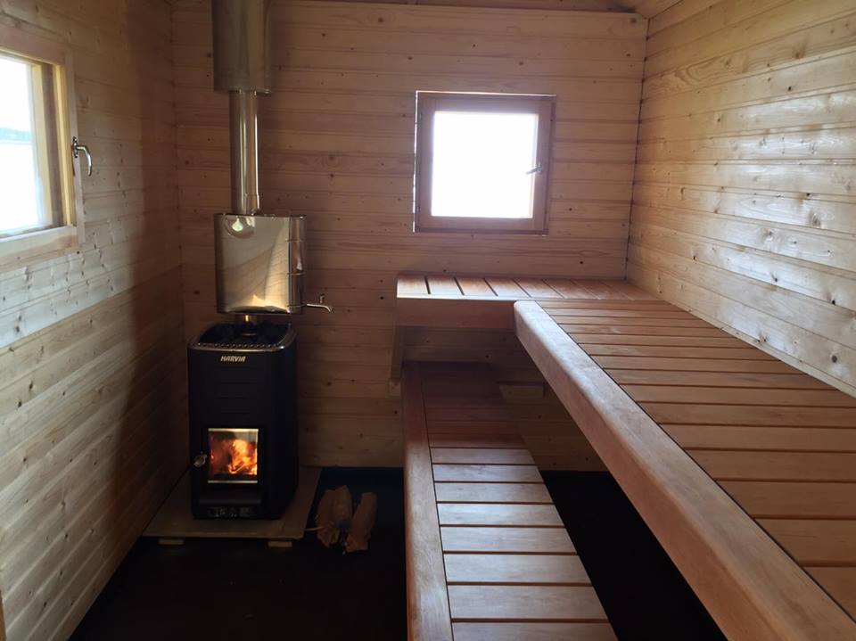 Wooden heated sauna with spruce walls and alder saunaseats